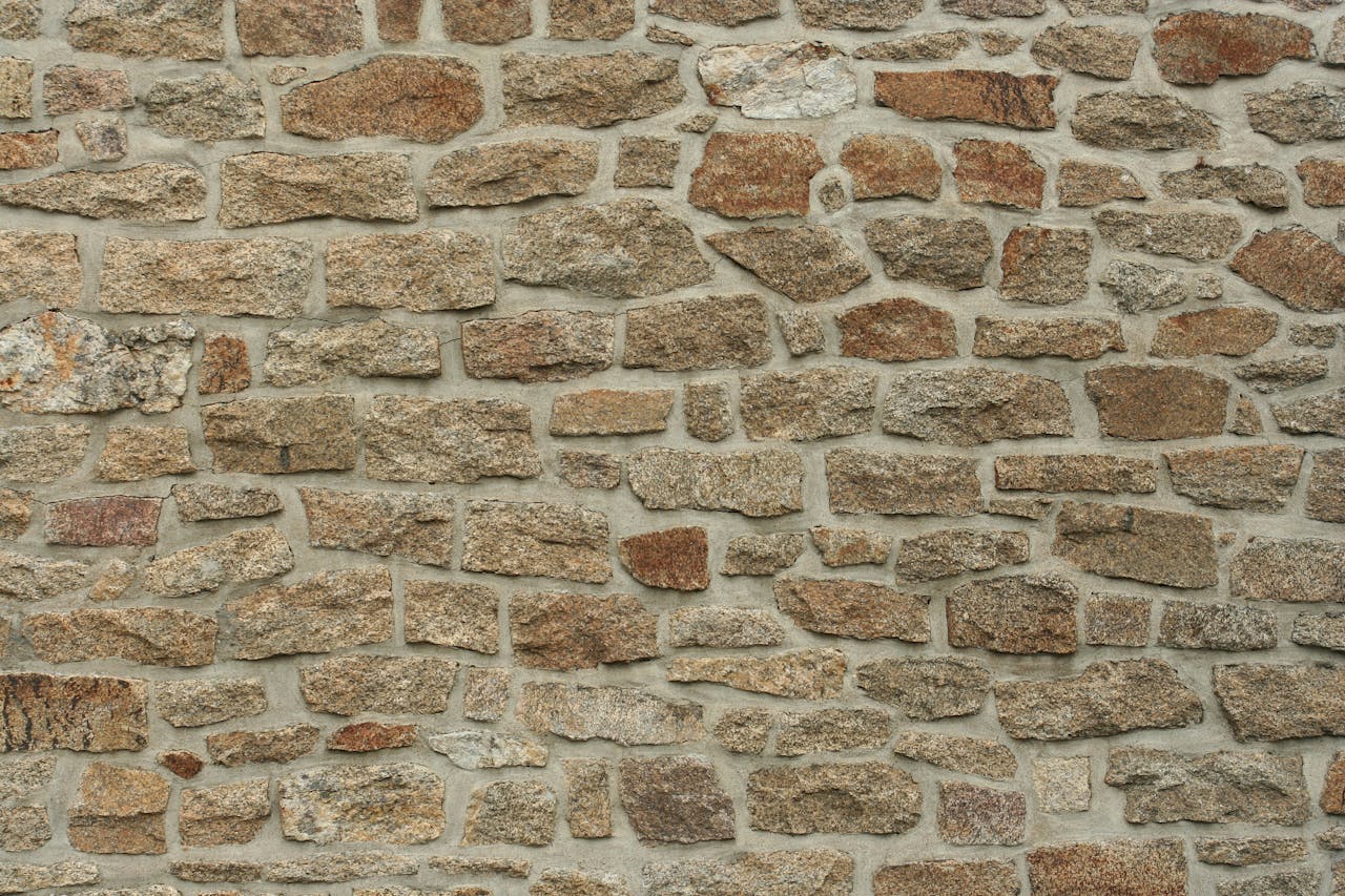 Services-02 Close-up of a rough stone wall texture in a vertical orientation, ideal for backgrounds.